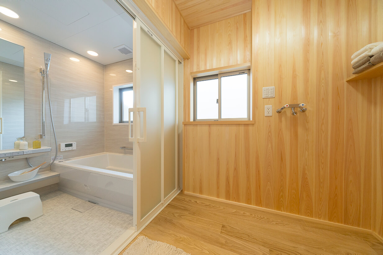 木質感ある脱衣室と白の浴室