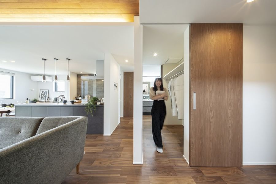 ファミリークローゼットからリネンを持って出てくる女性