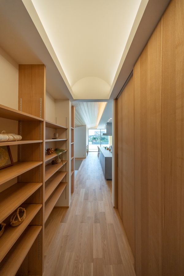 通路の両側に壁一面の書棚とクローゼット