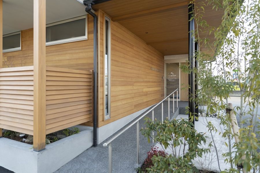 板張りのクリニック外観、入り口はスロープ