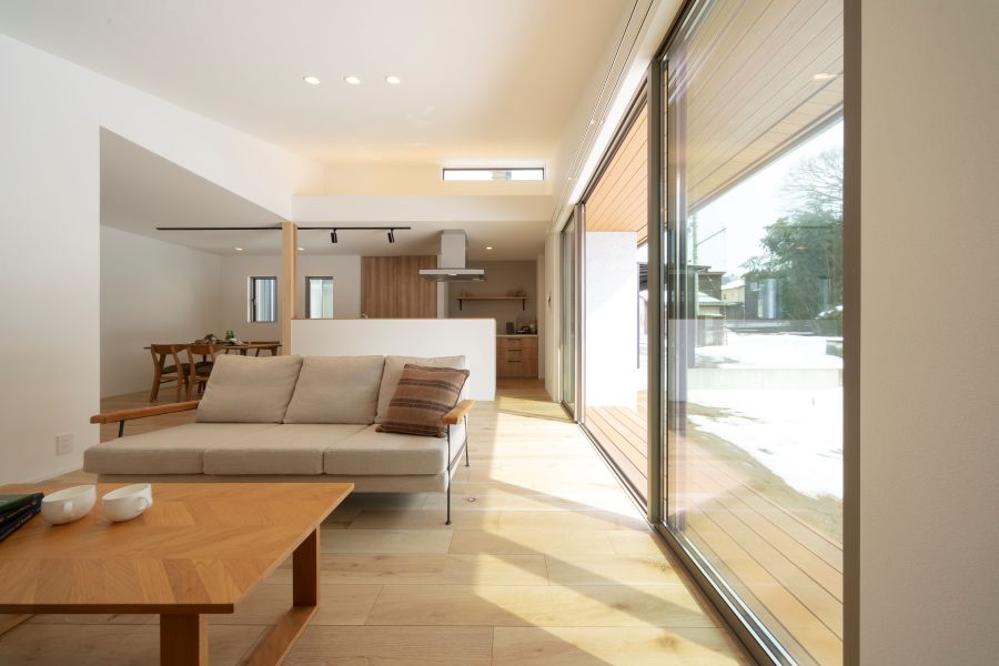 リビングの大開口の外に見える深い軒とウッドデッキ