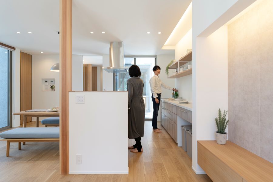 キッチンに立って会話する若い男女