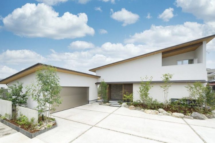 独立したガレージと庭でつながる家